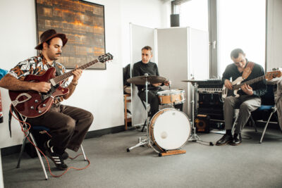 Eine Band aus drei Männern spielt Musik.