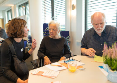 Sich unterhaltende Menschen an einem Tisch.