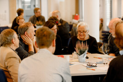 Sich unterhaltende Menschen an einem Tisch.