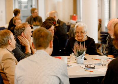 Sich unterhaltende Menschen an einem Tisch.
